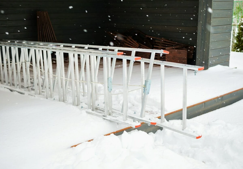 Ladder being stored inside a shed, away from snowfall.